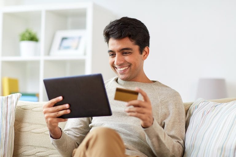 technology, people and online shopping concept - smiling man wit