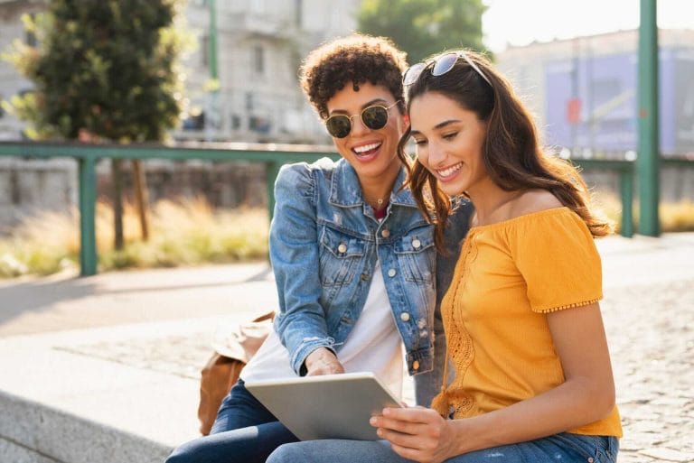 bigstock-Two-happy-girls-using-digital--292915288